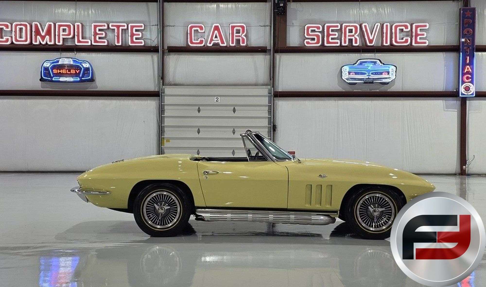 Side profile of the Sunfire Yellow 1965 Corvette convertible with knock-off wheels