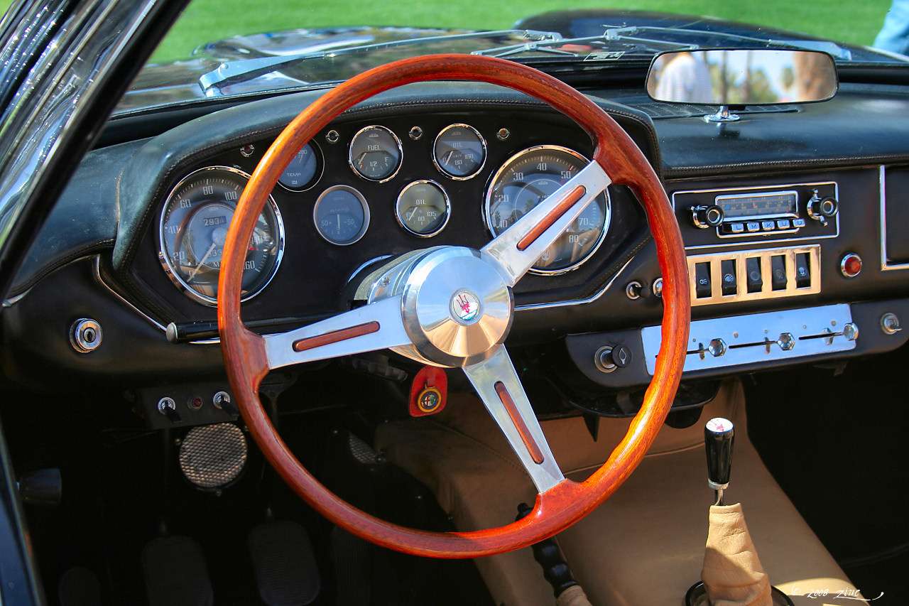 Wood-rimmed steering wheel and round Jaeger-style gauges in the dashboard of a 1965 Maserati Mistral Spyder