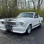White 1965 Ford Mustang Eleanor tribute fastback with black stripes, front three-quarter view