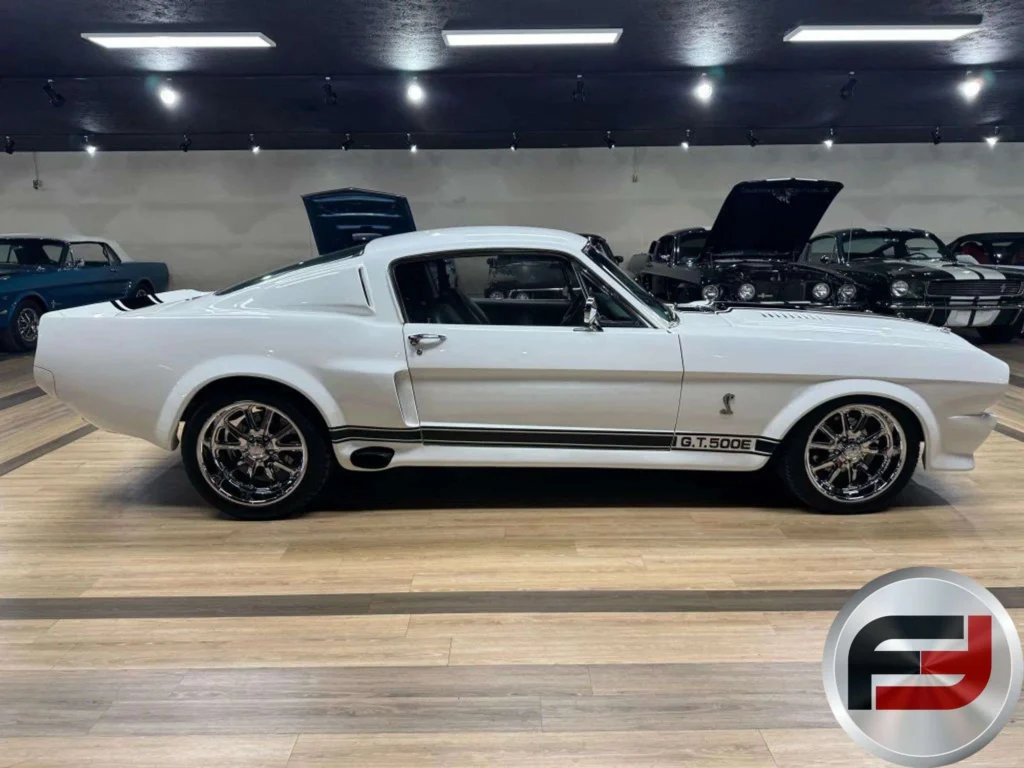 Side profile of the 1965 Ford Mustang Eleanor tribute fastback in white with black side stripes