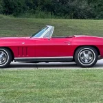 Side profile of the red 1966 Chevrolet Corvette convertible with the top down
