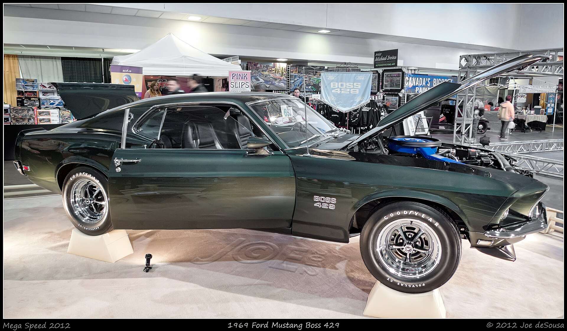 Dark green 1969 Ford Mustang Boss 429 fastback shown in side profile indoors