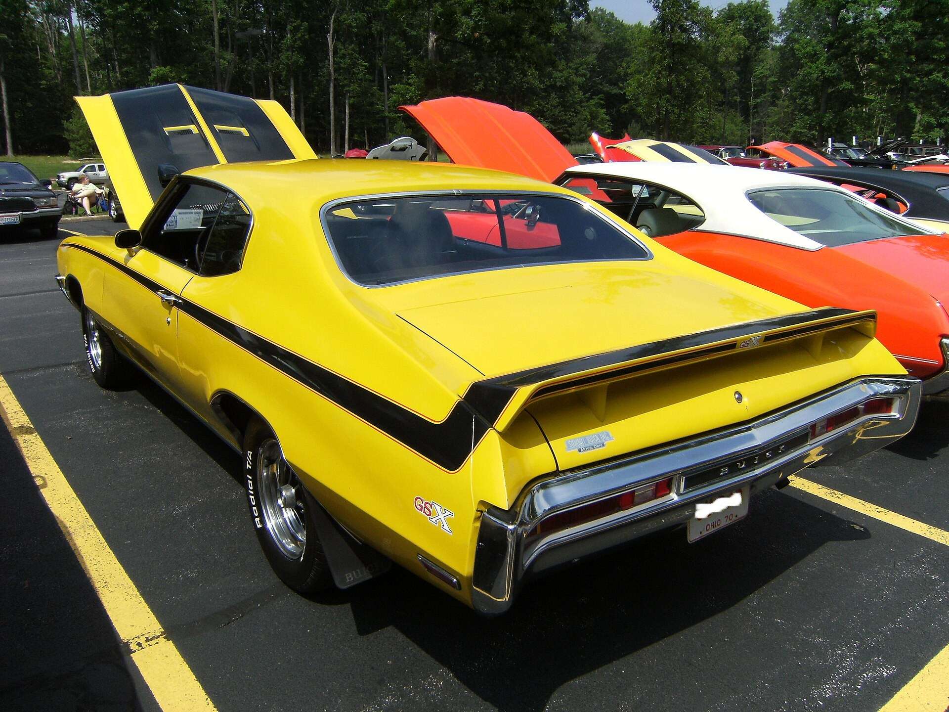 Rear three-quarter view of a Saturn Yellow 1970 Buick GSX showing the rear wing and black body-side graphics