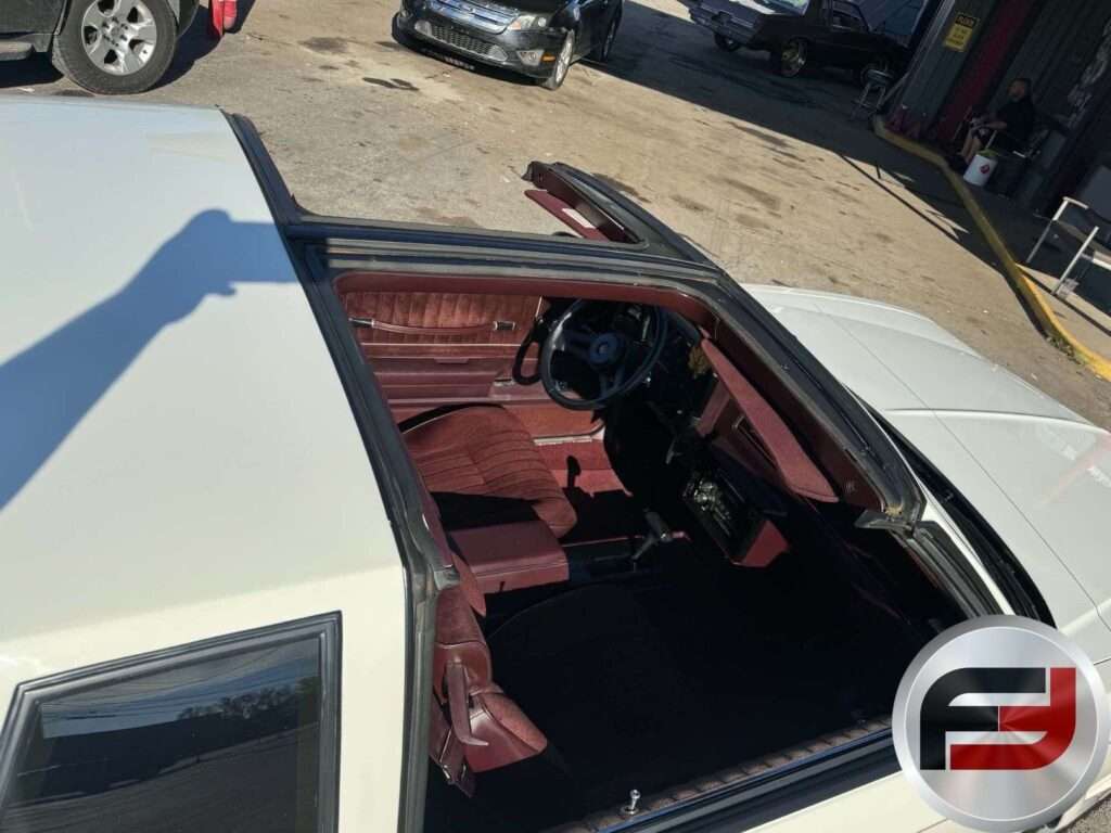 Maroon interior of the 1987 Monte Carlo SS Aerocoupe seen through the open T-top roof