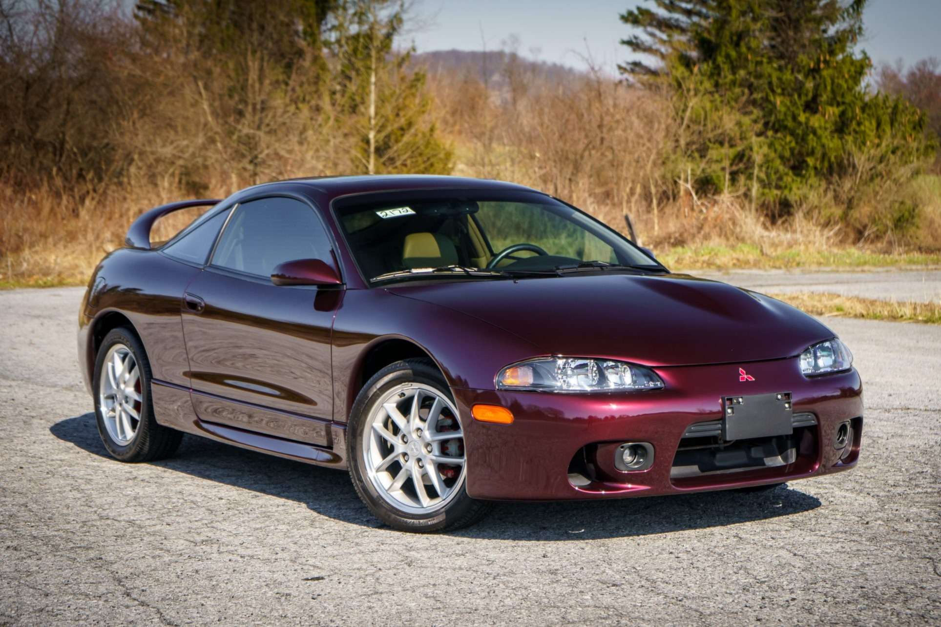 Dark red 1999 Mitsubishi Eclipse GSX coupe with split five-spoke wheels photographed on a country road