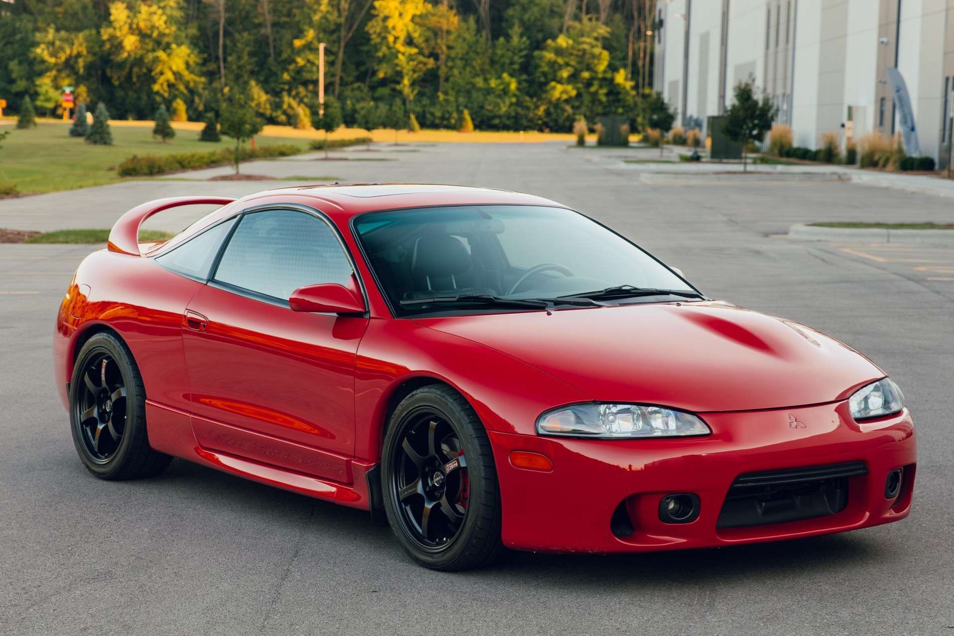Red 1999 Mitsubishi Eclipse GSX coupe with black wheels shown from the front three-quarter angle