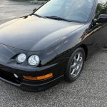 Front three-quarter view of a 2000 Acura Integra Type R in Flamenco Black Pearl with the Type R front chin spoiler and rear wing