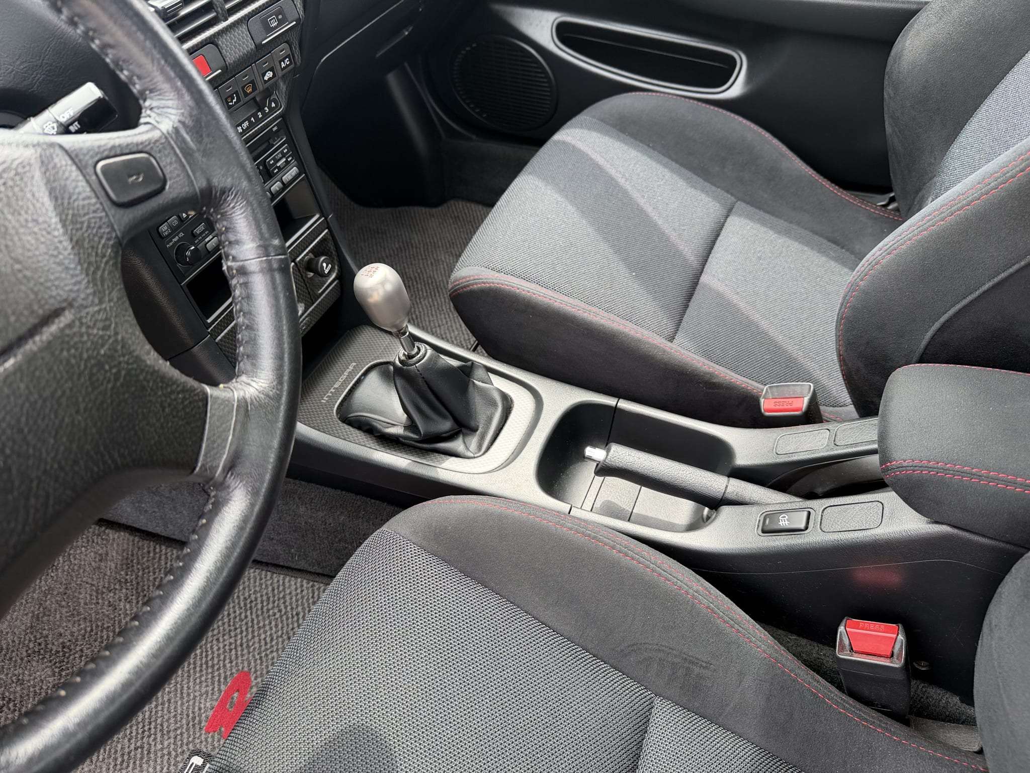 Black cloth and microsuede front seats with red stitching in a 2000 Acura Integra Type R