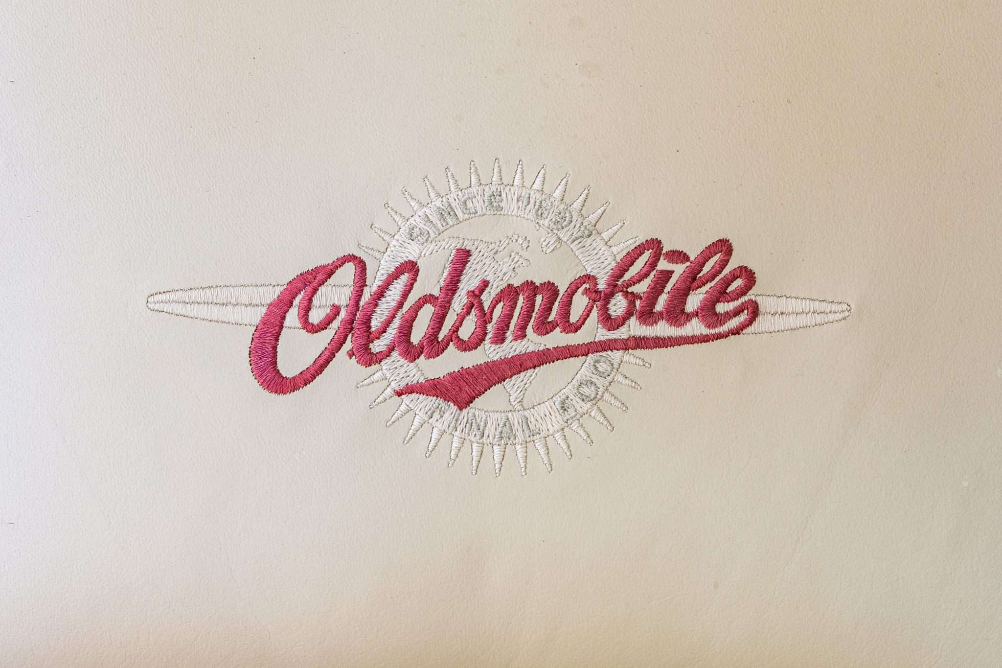 Oldsmobile Final 500 script embroidered on the Neutral leather seat back of a 2003 Aurora