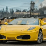 GAA Classic Cars Offers a 2,600-Mile 2006 Ferrari F430 Spider With No Reserve Front three-quarter view of the yellow 2006 Ferrari F430 Spider parked in a rail yard
