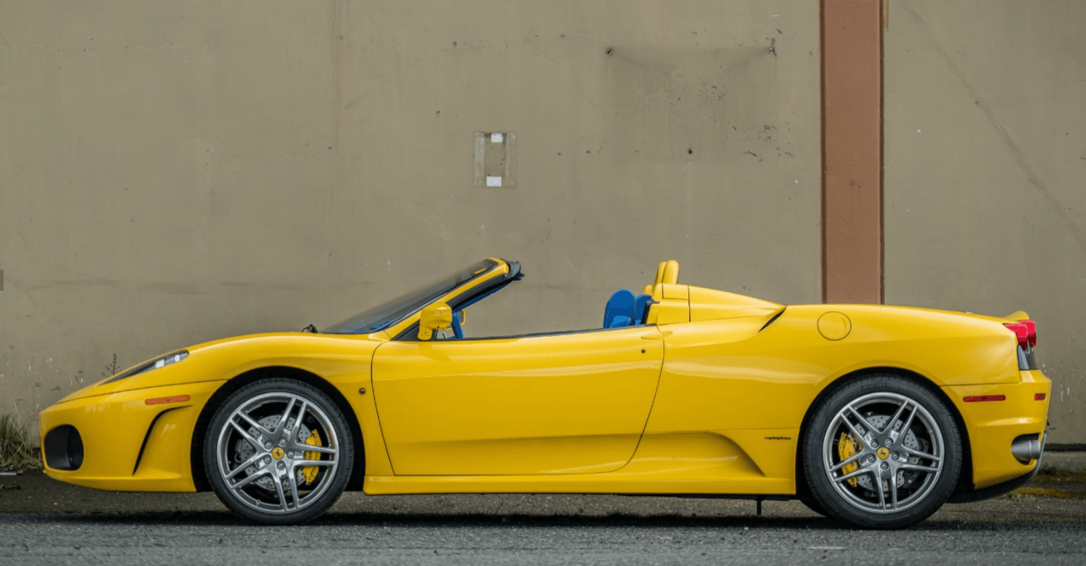 Side profile of the yellow 2006 Ferrari F430 Spider with its top down