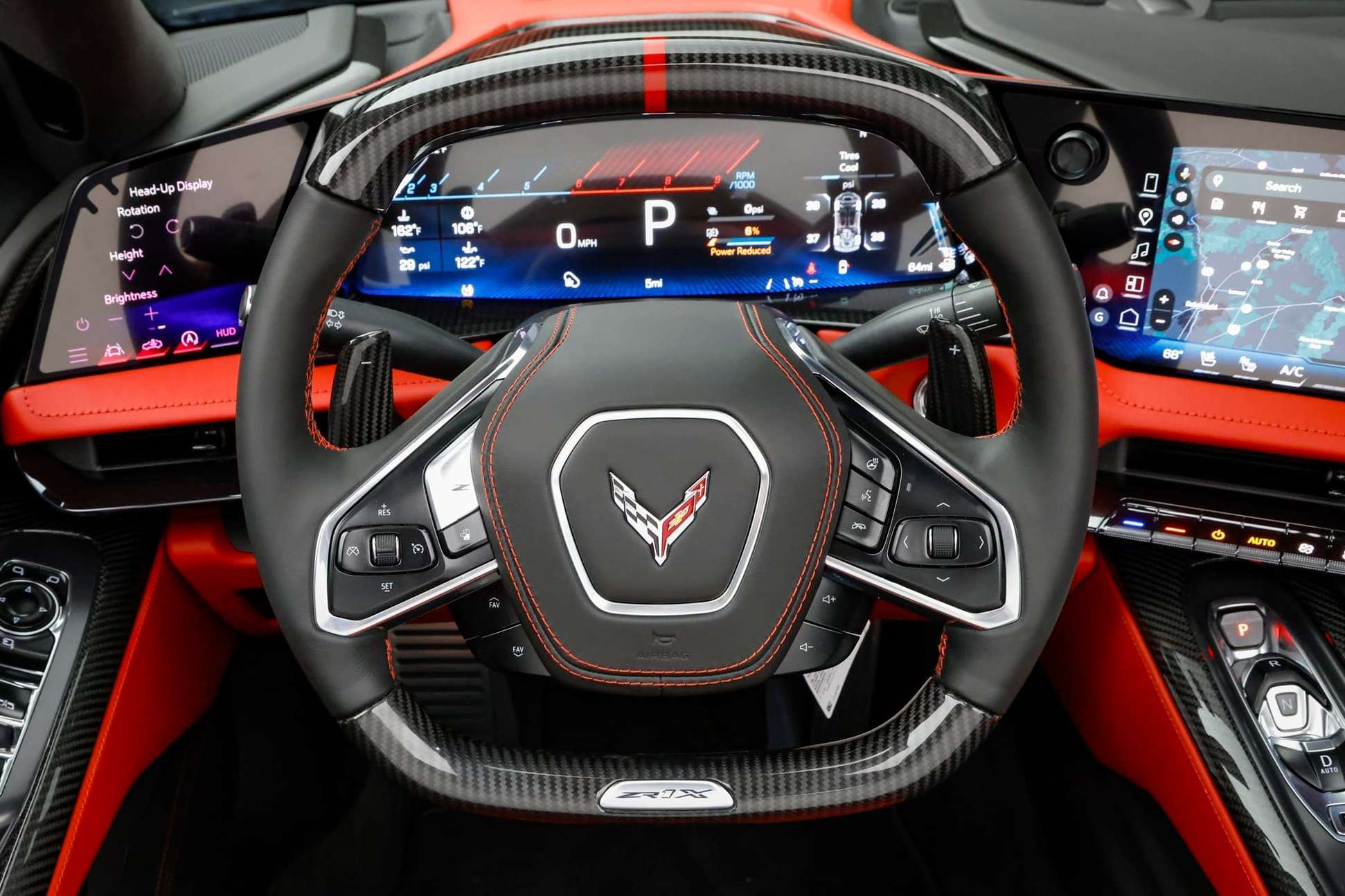 Cockpit of a 2027 Chevrolet Corvette ZR1X with carbon-fiber steering wheel and Adrenaline Red trim