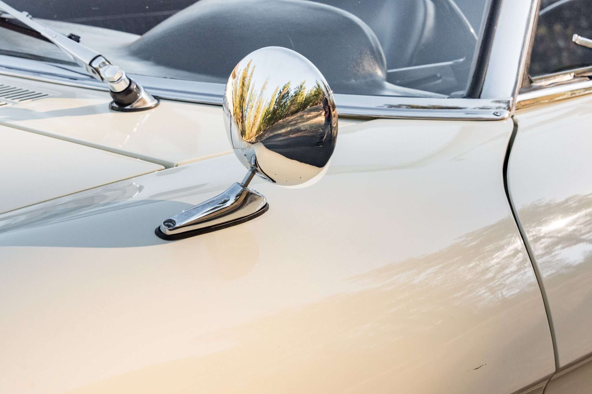 Chrome mirror mounted on the front fender of a 1966 Alfa Romeo 1600 Spider