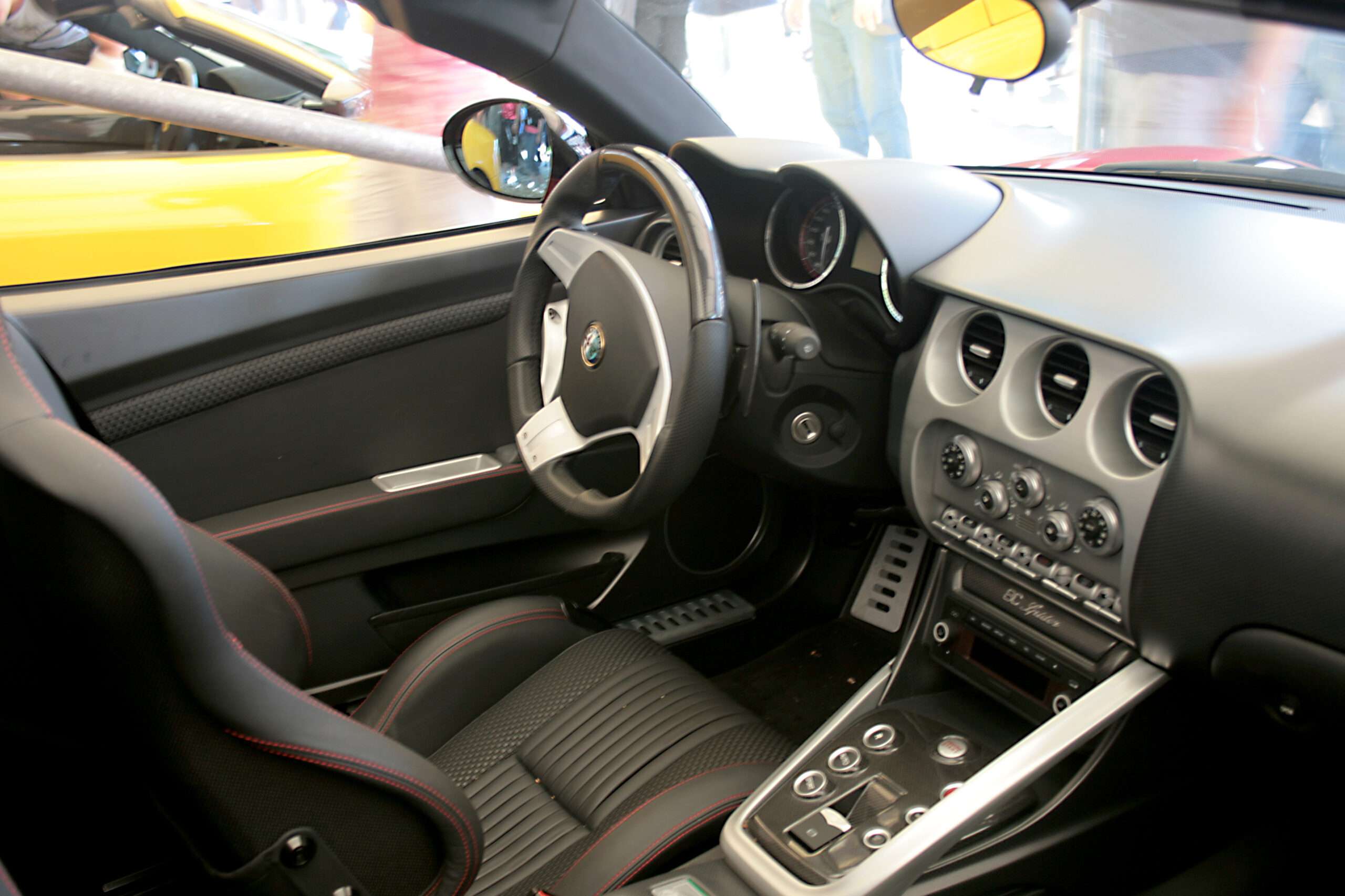 Interior of an Alfa Romeo 8C Spider showing the steering wheel, dashboard and centre console