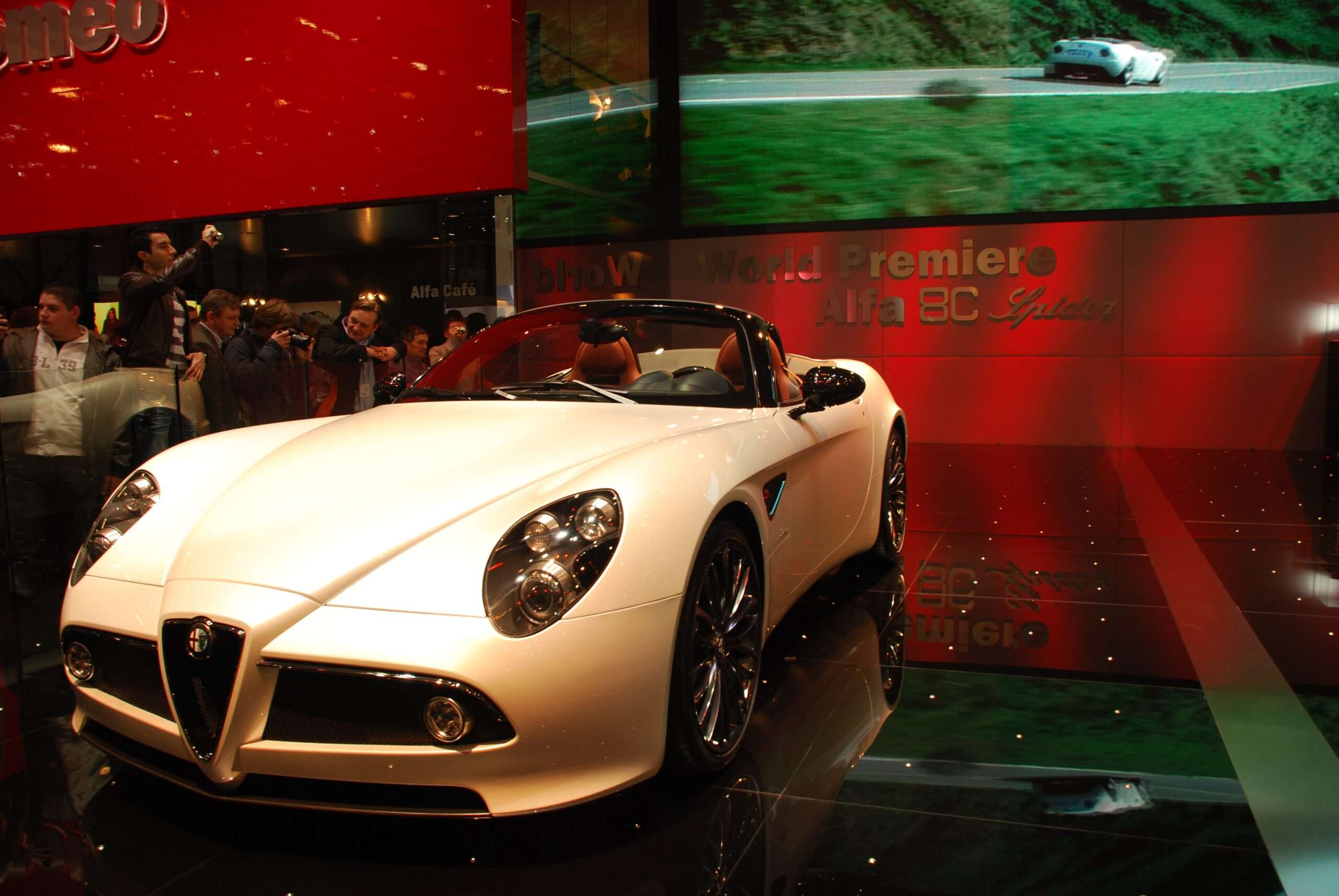 White Alfa Romeo 8C Spider roadster displayed on a motor show stand