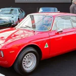 Red 1965 Alfa Romeo Giulia Sprint GTA coupe photographed from the front three-quarter on a show stand