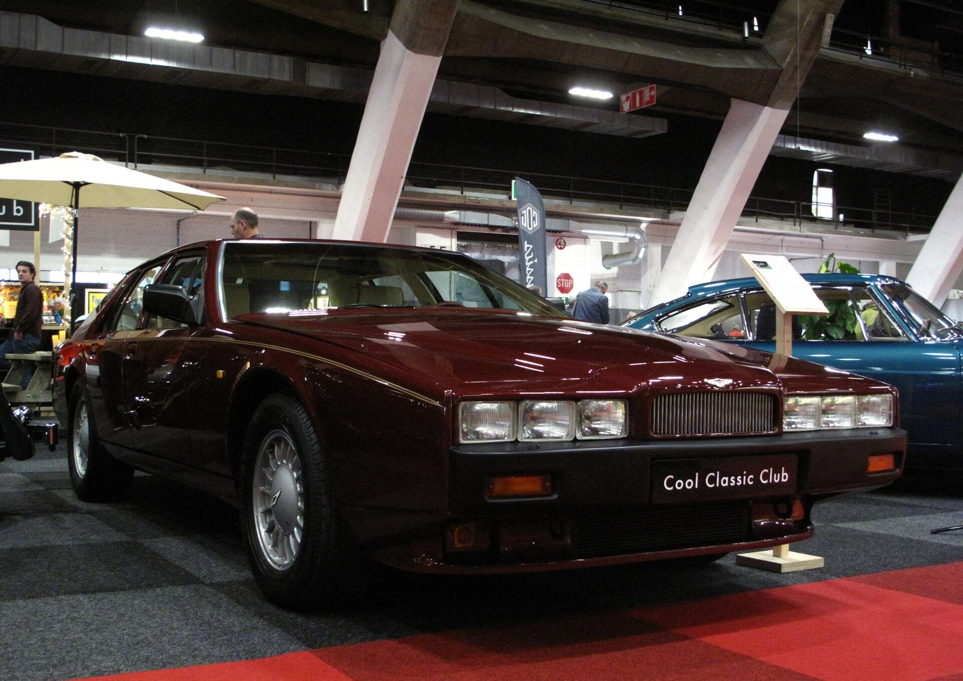 Dark red 1990 Aston Martin Lagonda 5.3 V8 on indoor display with its low wedge nose facing the camera