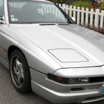 Silver BMW E31 850CSi coupe photographed from the front three-quarter on a residential street