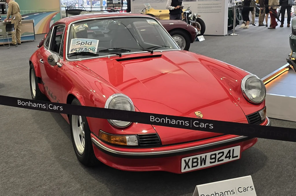 Red 1973 Porsche 911 Carrera RS 2.7 with UK registration at a Bonhams display