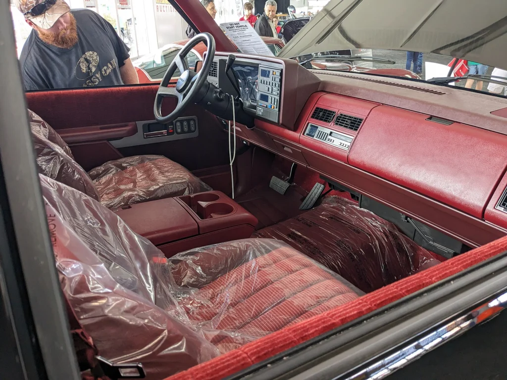 Red interior of an as-new 1990 Chevrolet 454 SS pickup with factory plastic still covering the seats