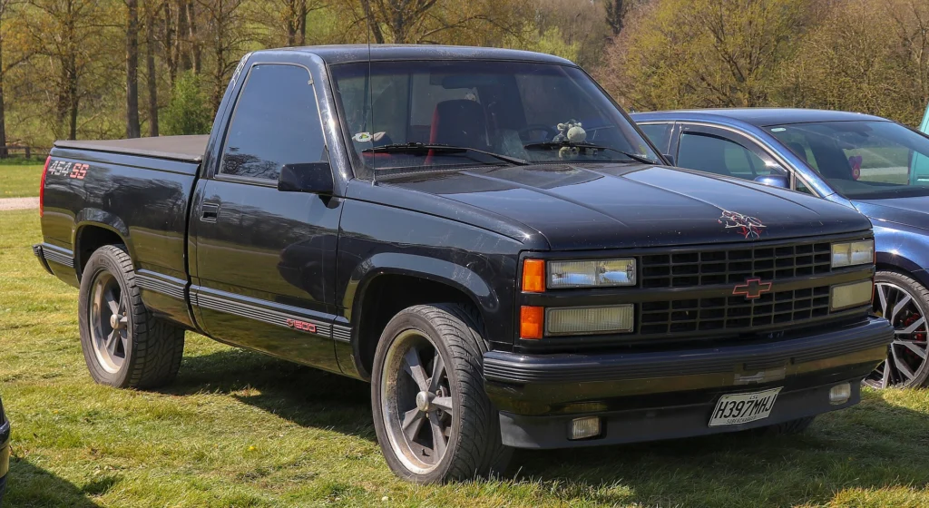 Black 1990 Chevrolet C1500 454 SS short-bed pickup parked on grass in front three-quarter view