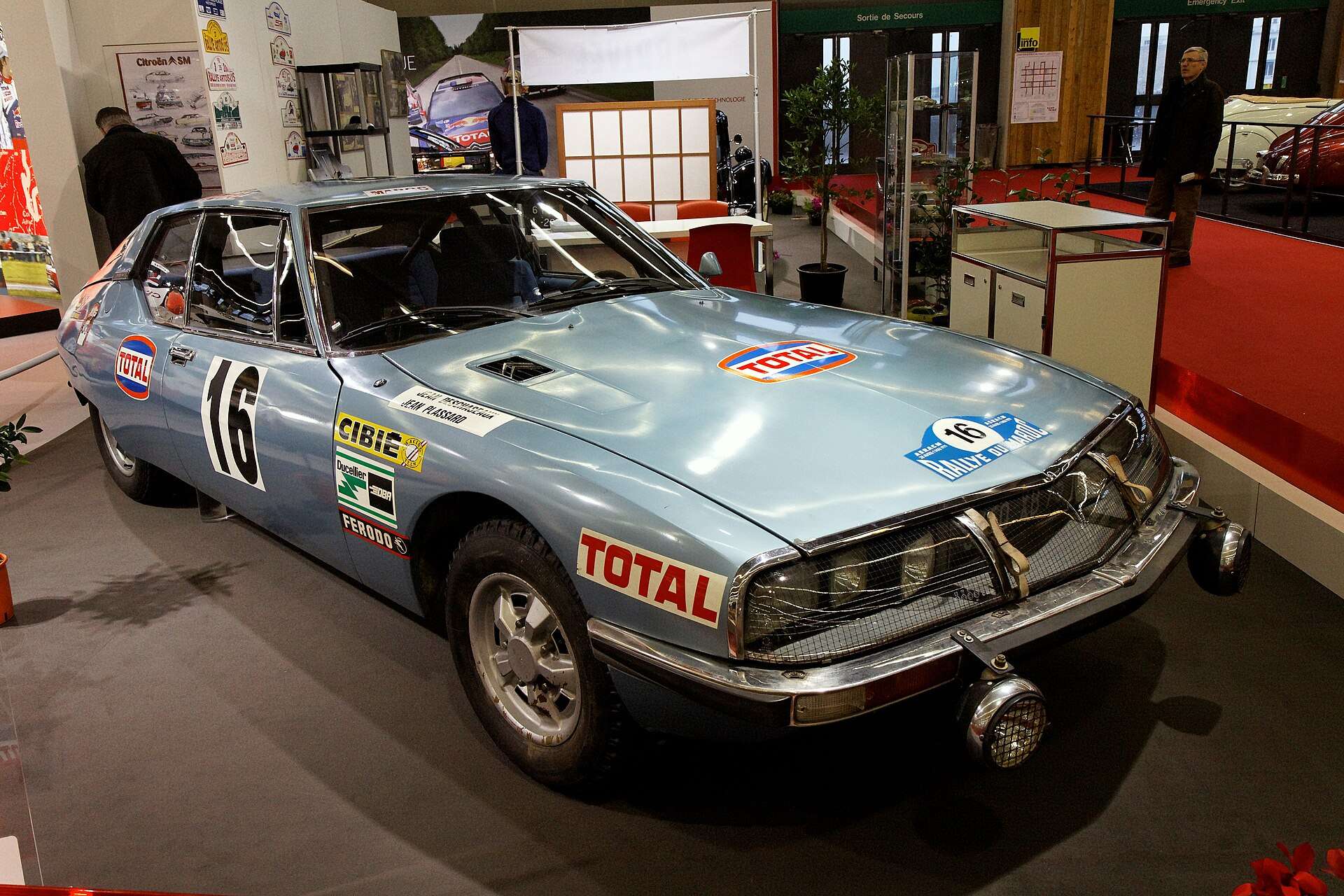 Silver Citroën SM rally car in Total livery with race number 16 displayed indoors at Rétromobile