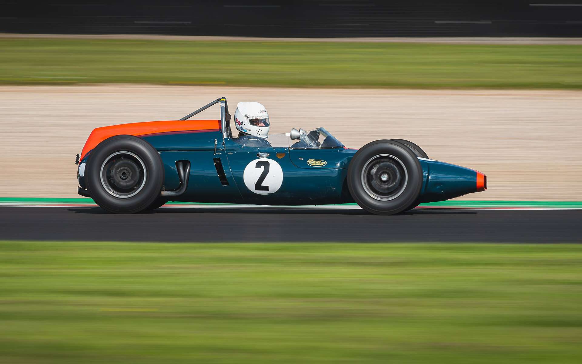 Teal and orange 1961 Cooper T53 number 2 rear-engined race car in a historic race at Donington Park