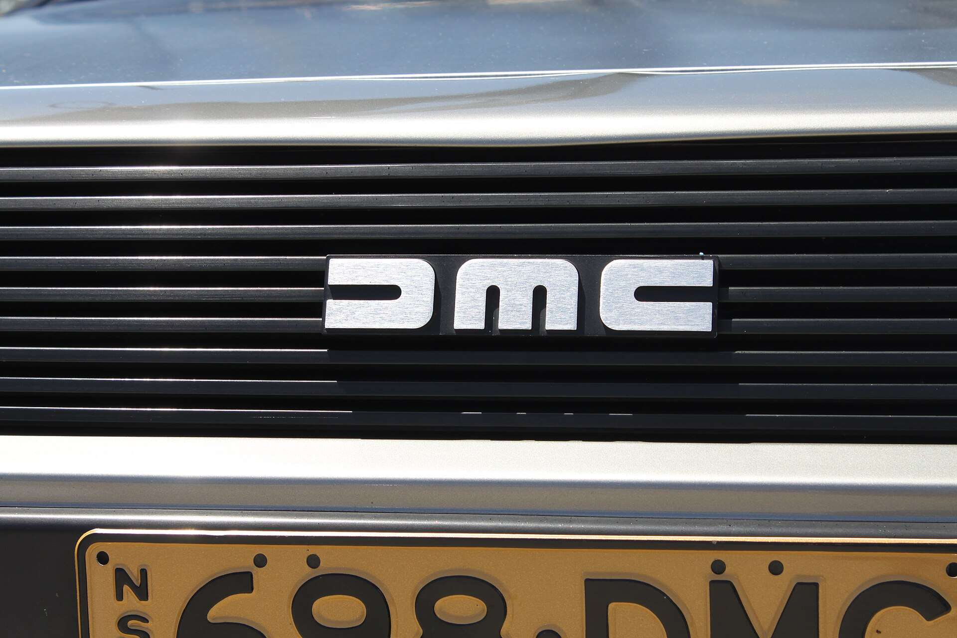Close view of the DMC badge on the rear of a DeLorean DMC-12