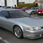 Silver Mazda Eunos Cosmo 20B coupe parked at Okayama International Circuit, front three-quarter view