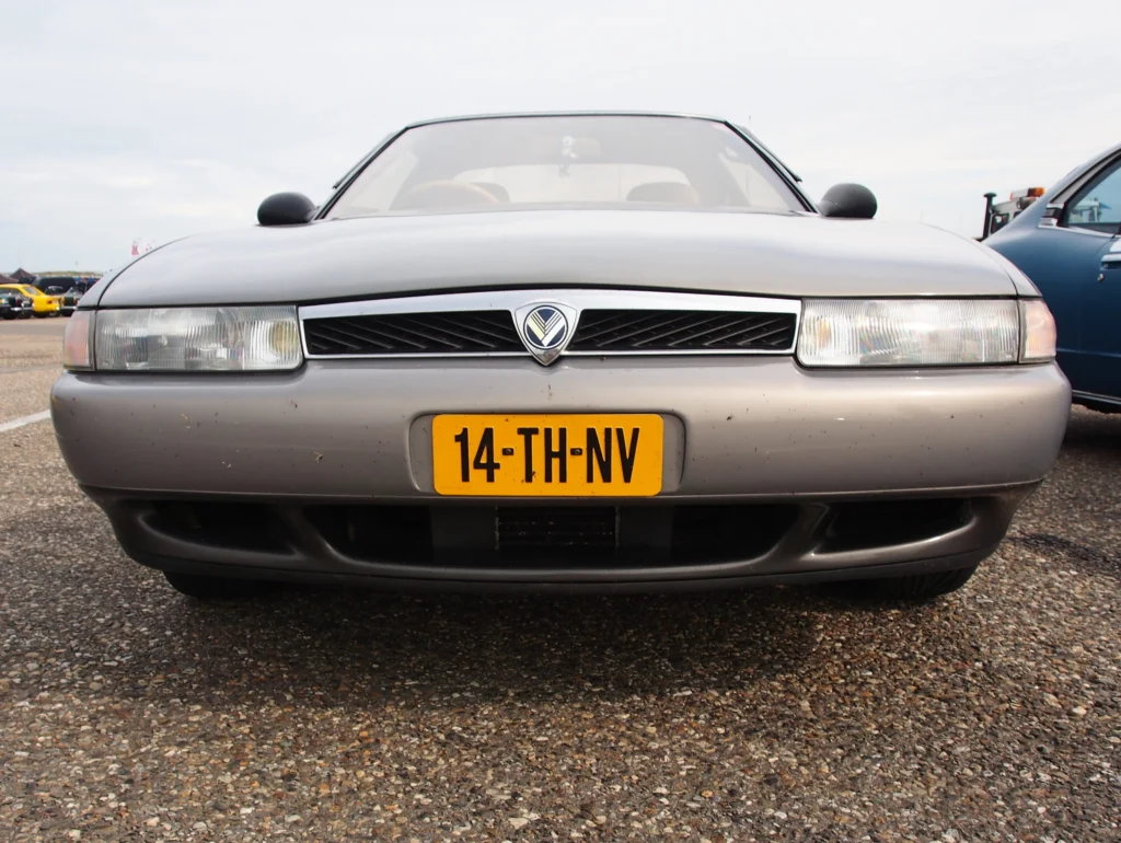 Head-on front view of a grey 1990 Eunos Cosmo showing its horizontal grille and wraparound headlamps