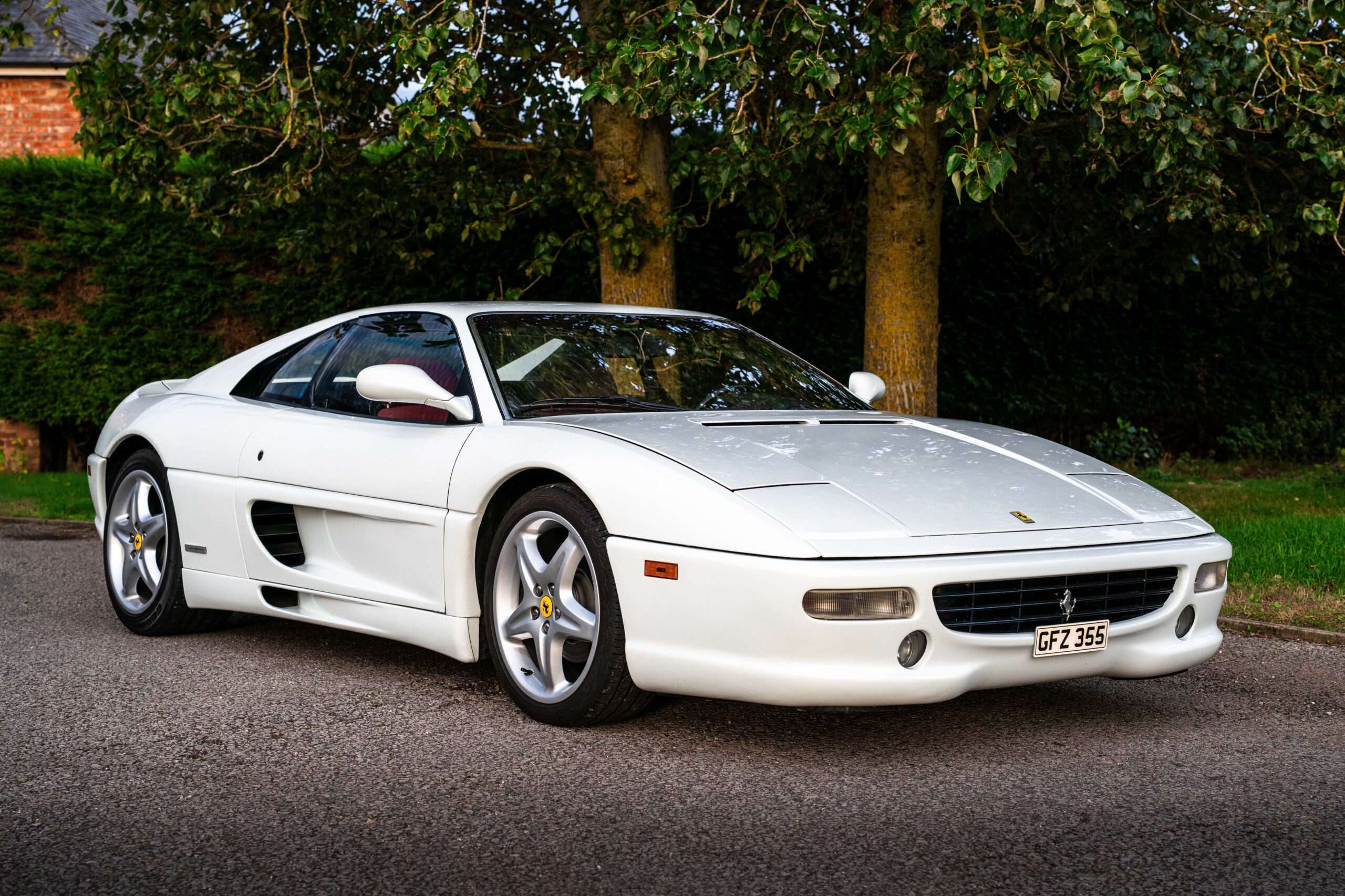 White 1995 Ferrari F355 Berlinetta seen from the front, parked on a driveway