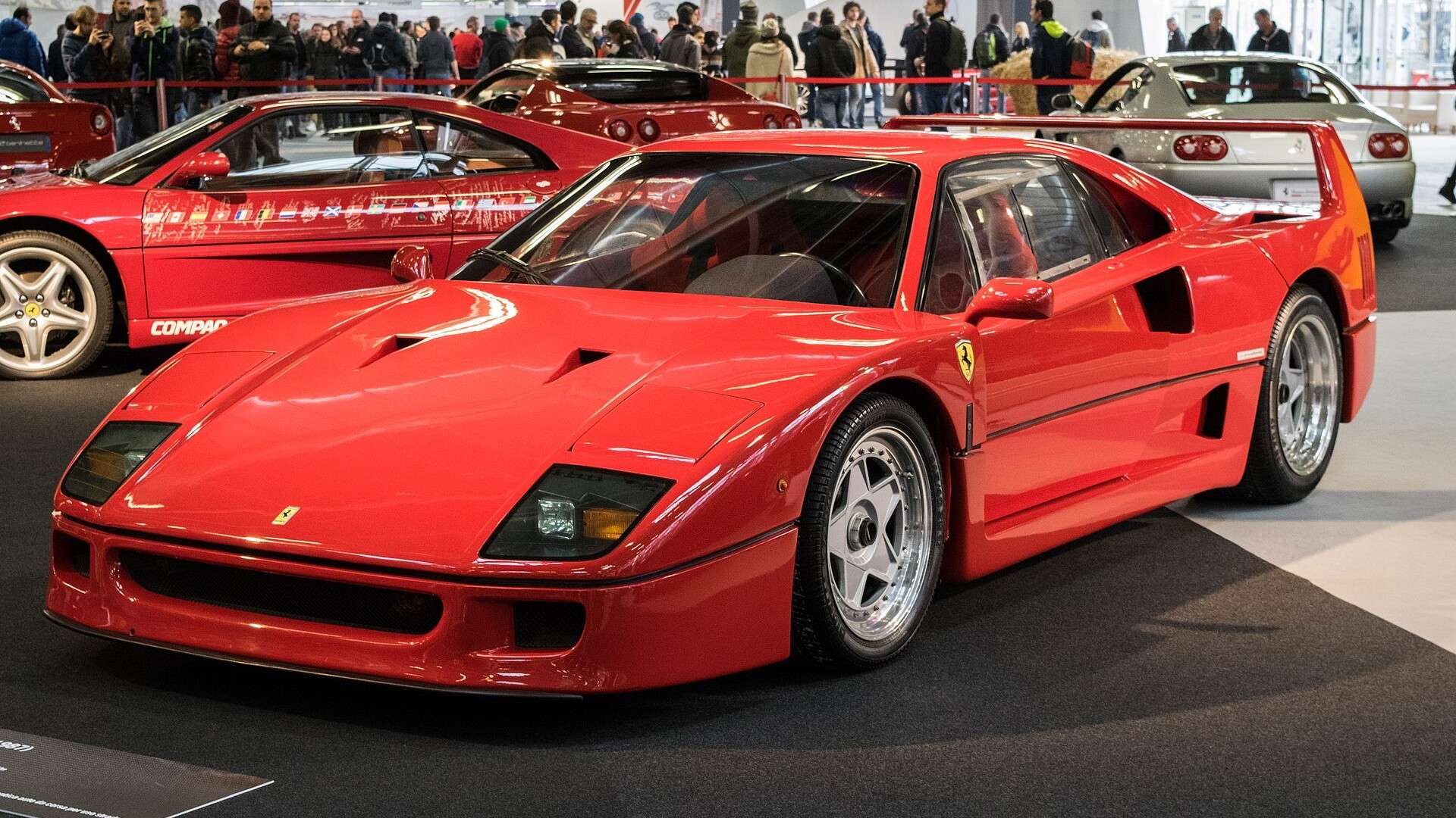 Red Ferrari F40 parked outdoors, front three-quarter view