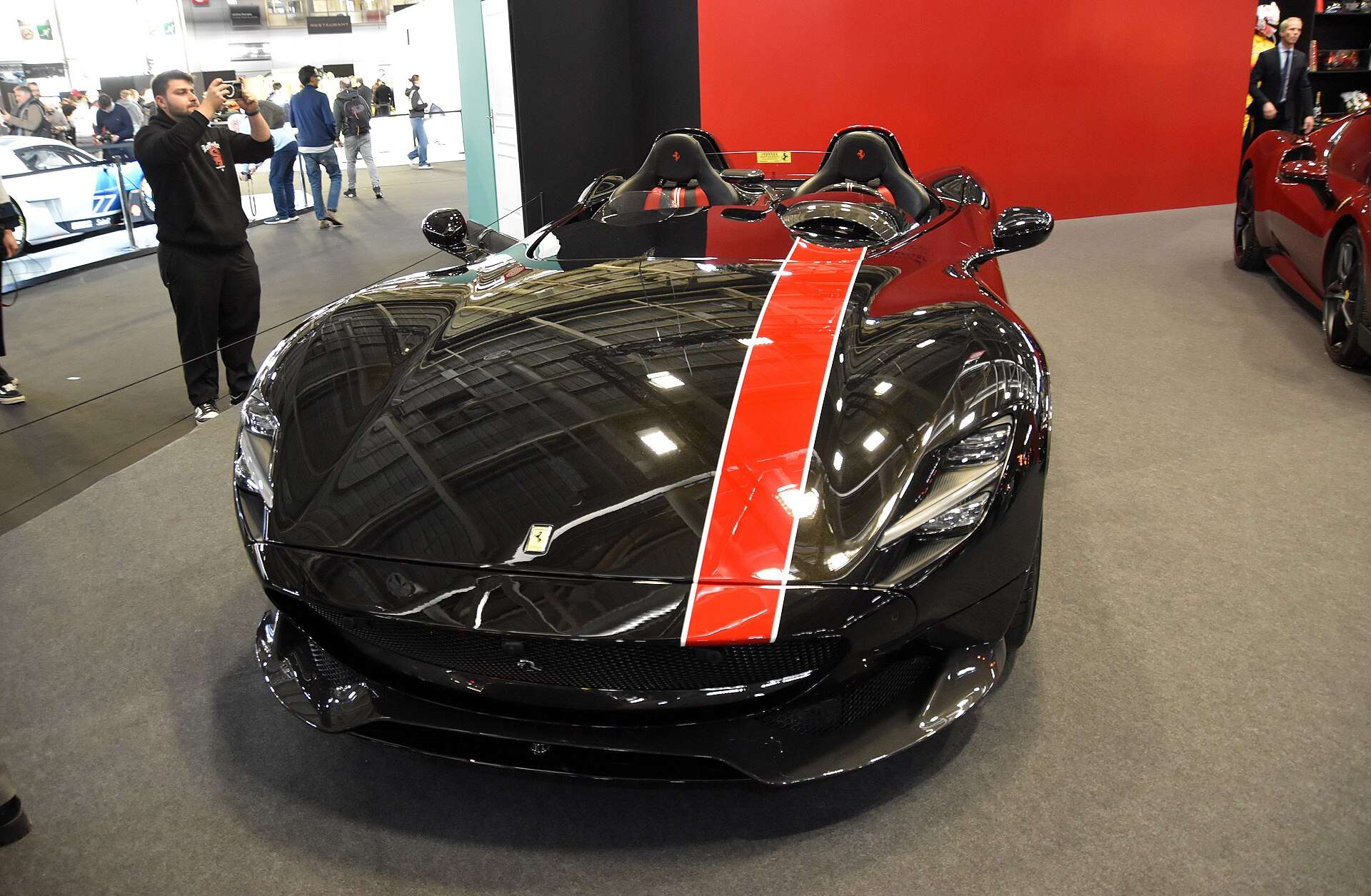 Black Ferrari Monza SP2 with red stripe at an auto show; the 2026 auction record reset Ferrari Monza SP2 value expectations