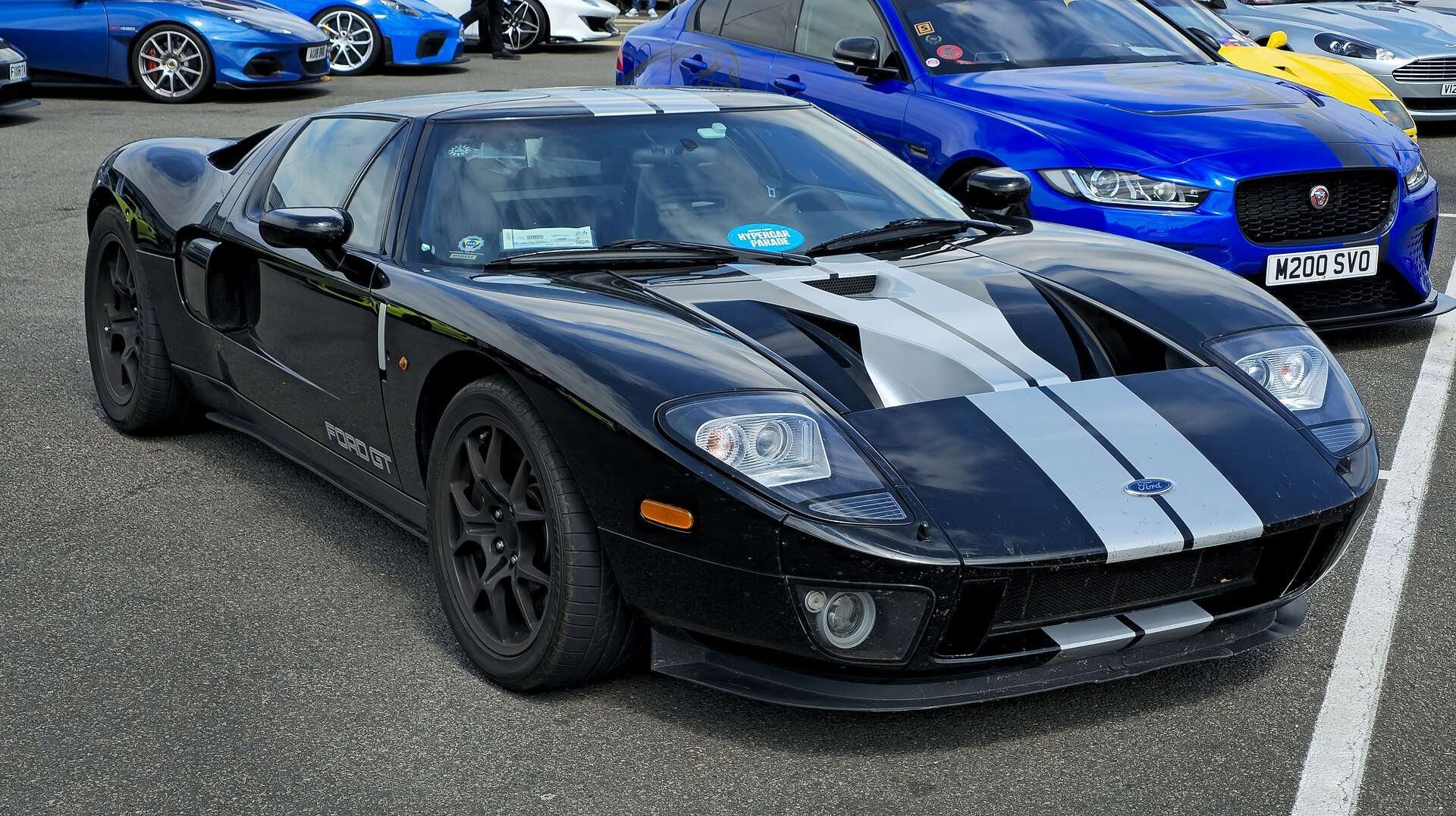 2005 Ford GT with racing stripes at an enthusiast meet