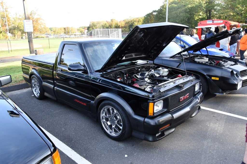 1991 GMC Syclone with the hood raised showing the turbocharged 4.3-liter V6 at a car show