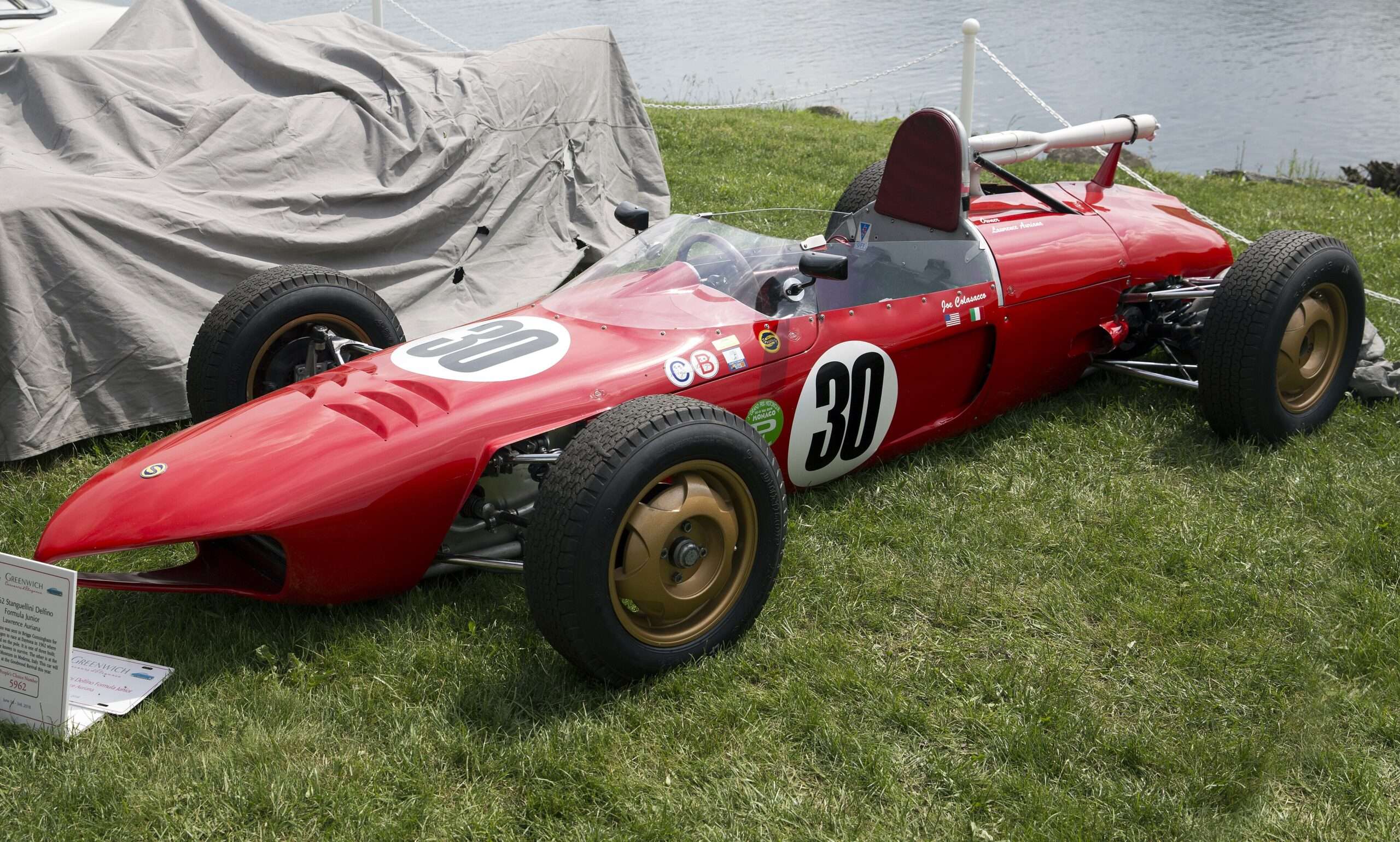 Red 1962 Stanguellini Delfino Formula Junior open-wheel race car displayed on a lawn at the Greenwich Concours d’Elegance