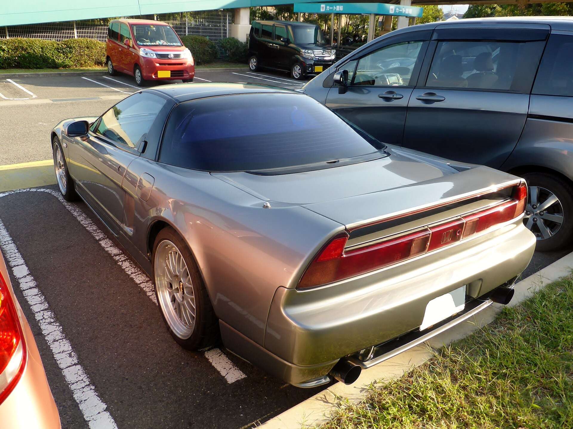 Rear three-quarter view of a first-generation Honda NSX with aftermarket wheels