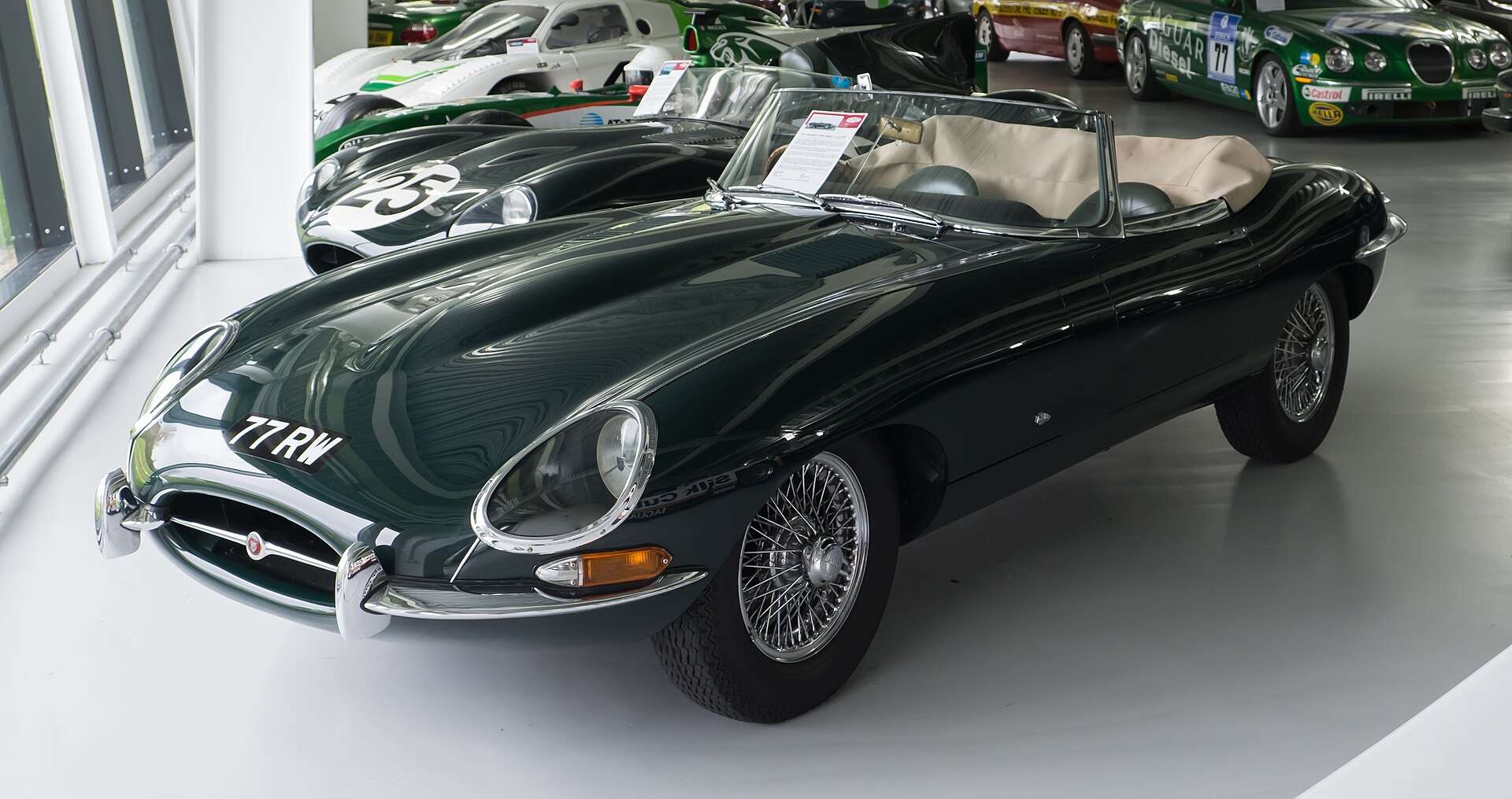 Dark green 1961 Jaguar E-Type Series 1 3.8-litre roadster on a showroom floor