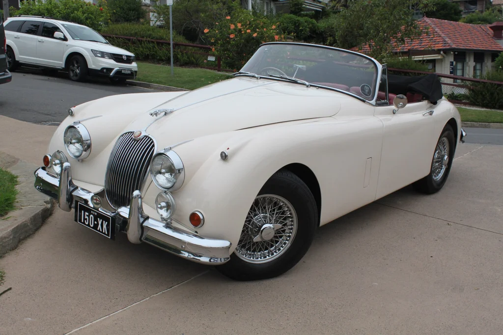 Cream 1959 Jaguar XK150 with wire wheels and the soft top folded down
