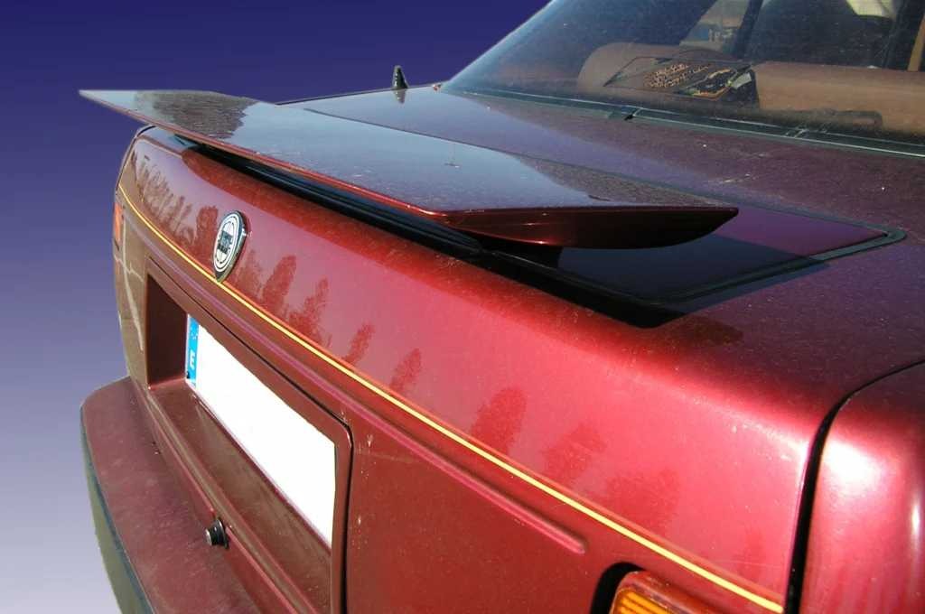 Extended rear spoiler on the trunk lid of a burgundy Lancia Thema 8.32 sedan