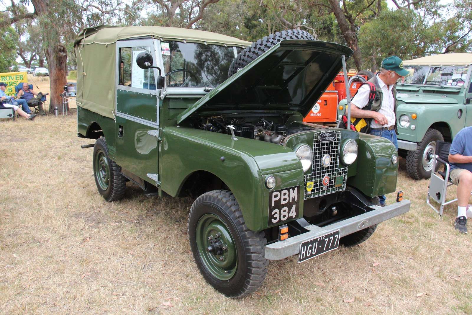 Green 1953 Land Rover Series I 80-inch with the bonnet raised and headlamps visible through the front grille