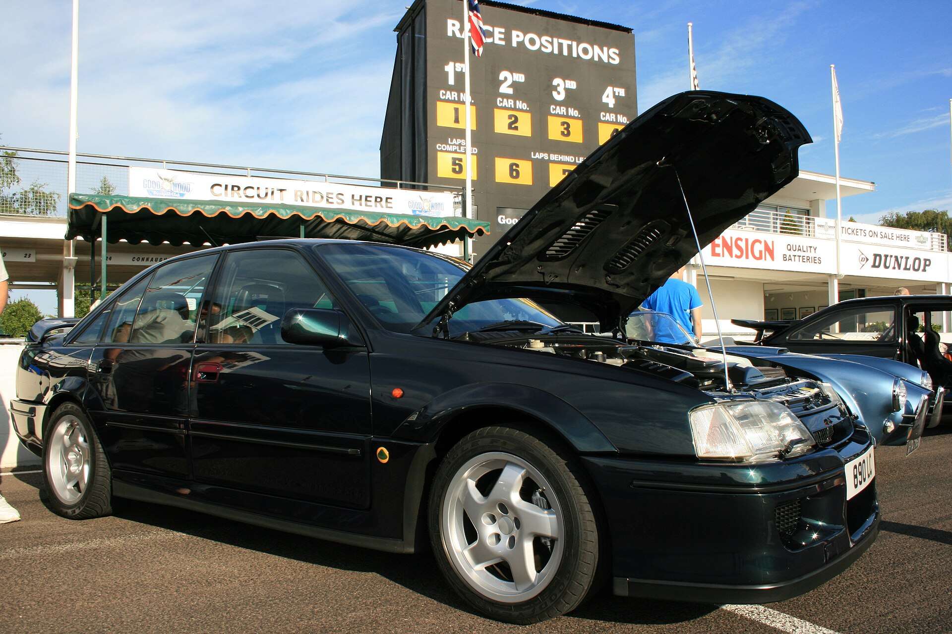 Vauxhall Lotus Carlton with its bonnet raised at a circuit paddock