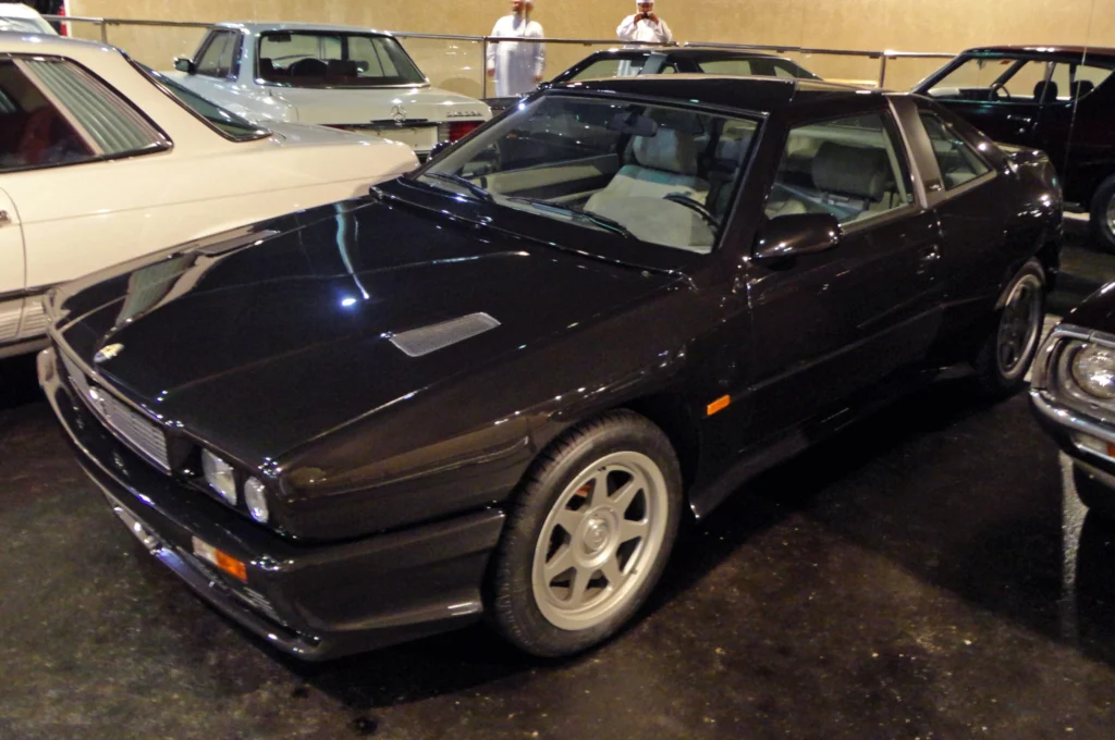 Black 1991 Maserati Shamal on display at the Emirates National Auto Museum showing its front three-quarter and bonnet vent
