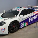 Silver McLaren F1 road car parked, seen from the front three-quarter angle
