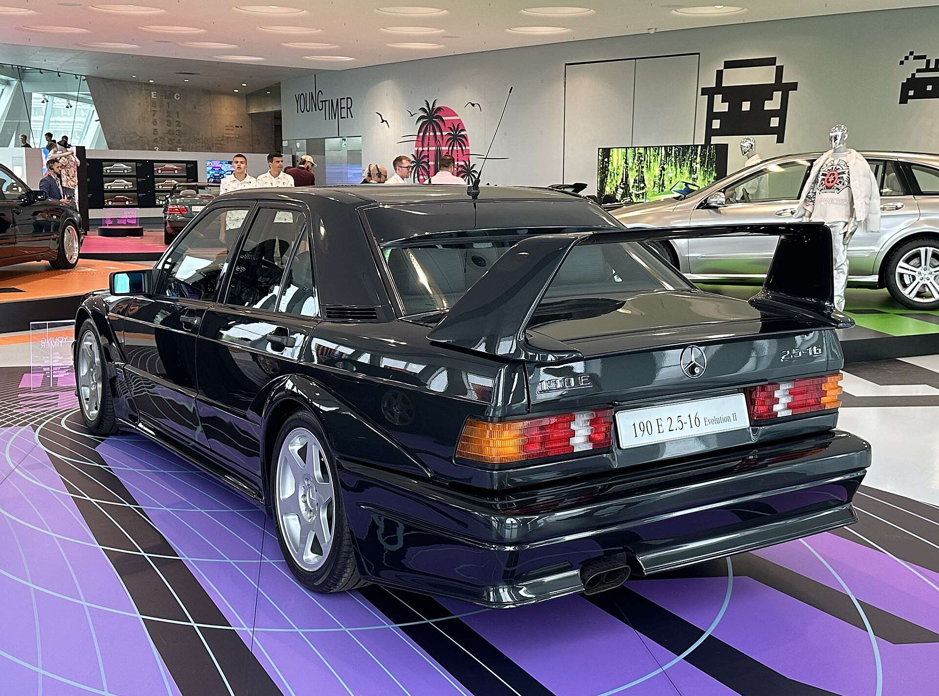 Rear three-quarter view of a black Mercedes-Benz 190E 2.5-16 Evo II showing the large adjustable rear wing and 190 E 2.5-16 Evolution II badge