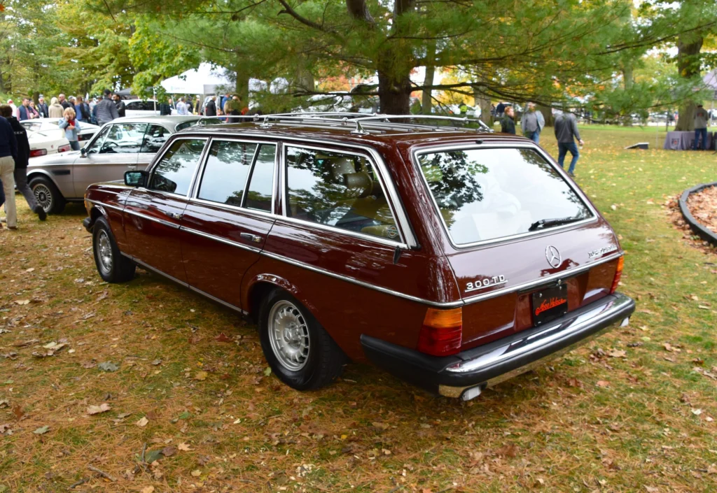 Rear three-quarter view of a burgundy 1983 Mercedes-Benz 300 TD Turbo S123 wagon showing its long roof, roof rails and tailgate