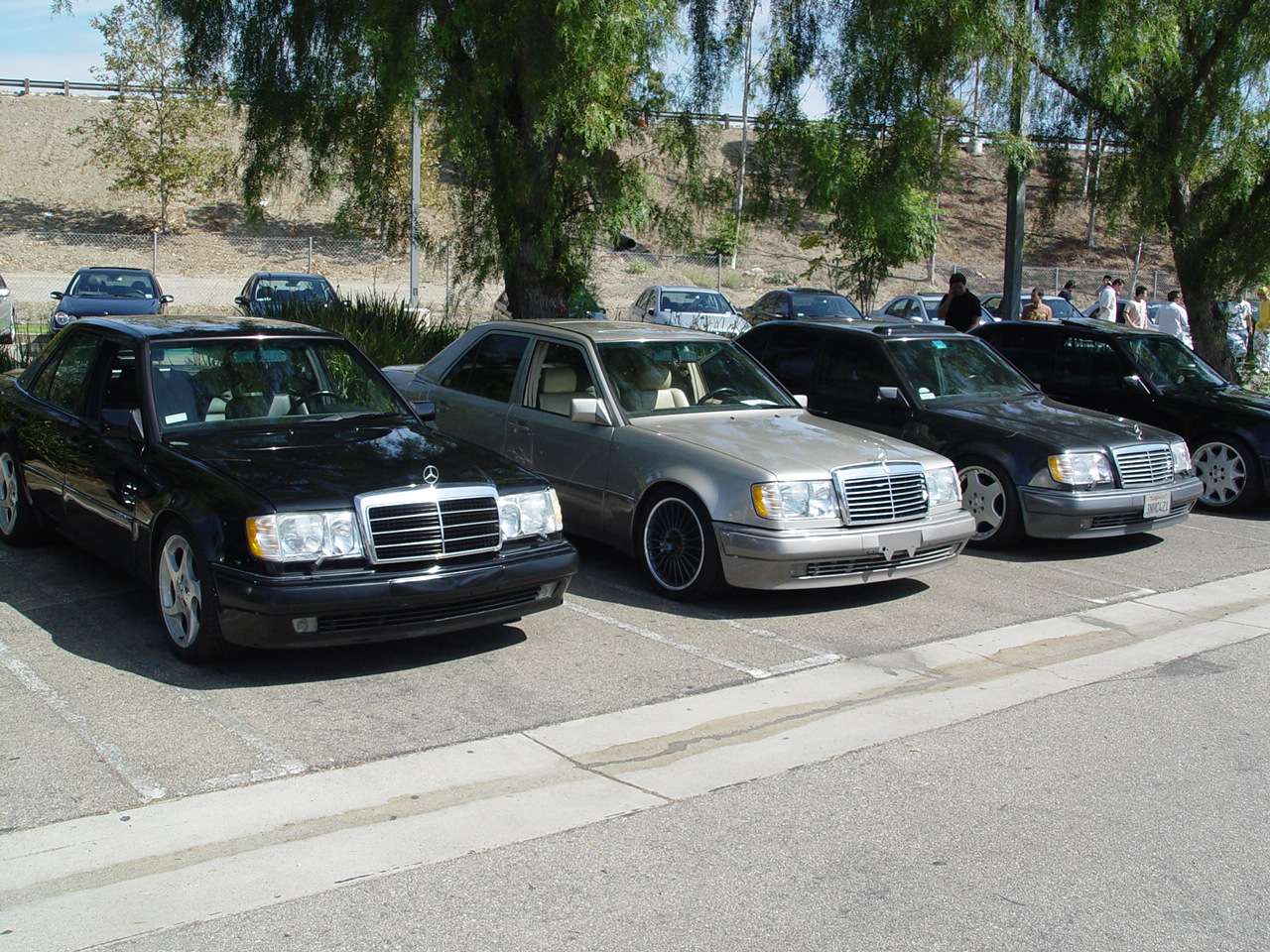 Two Mercedes-Benz 500E sedans and one E 500 parked side by side in a lot, showing the wide-fender W124 body