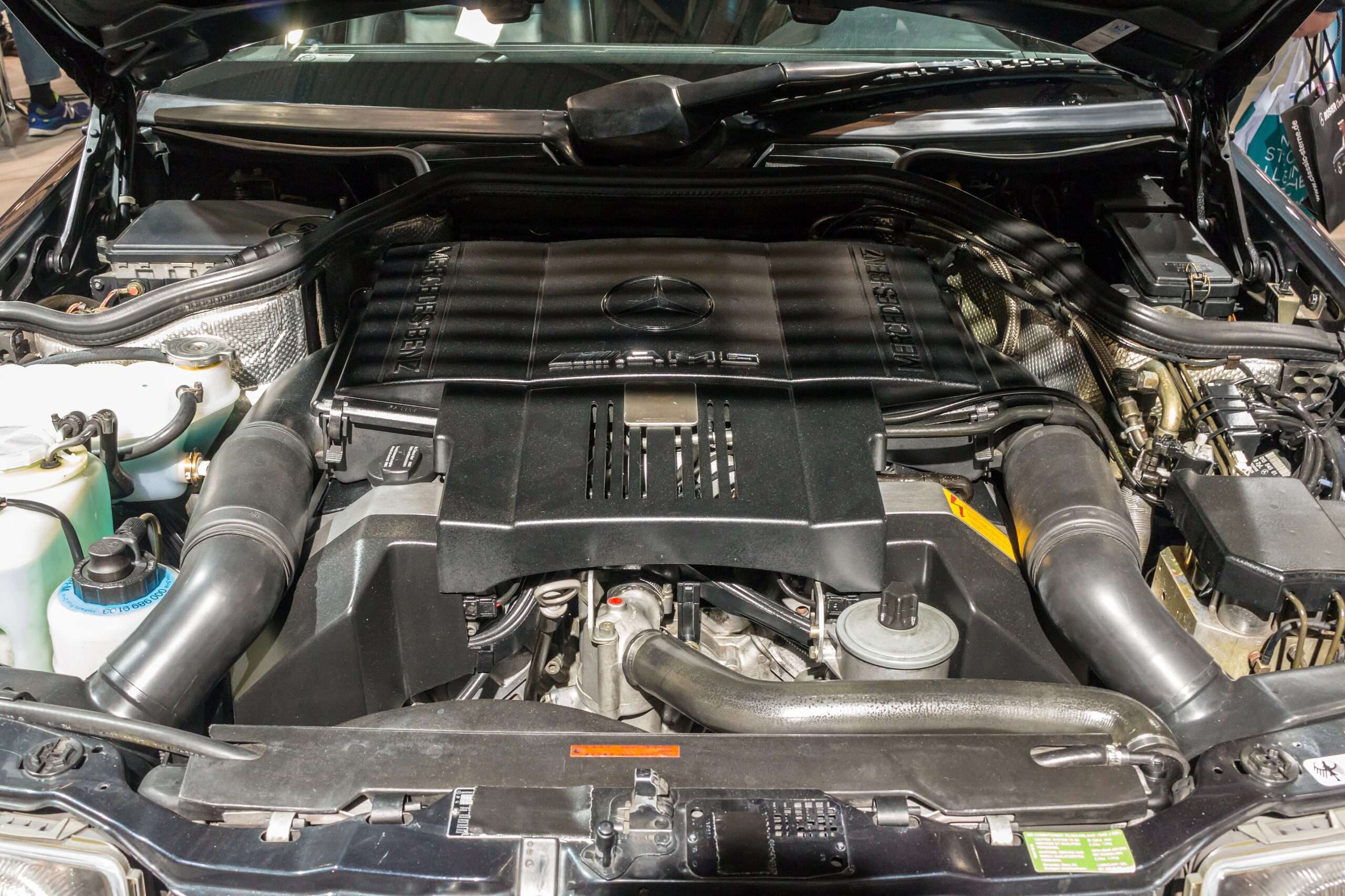 Mercedes-AMG M119 E60 6.0-liter V8 engine under the hood of a W124 on display