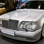 Silver 1994 Mercedes-Benz E 500 W124 sedan seen from the front three-quarter with the facelifted grille and headlamps