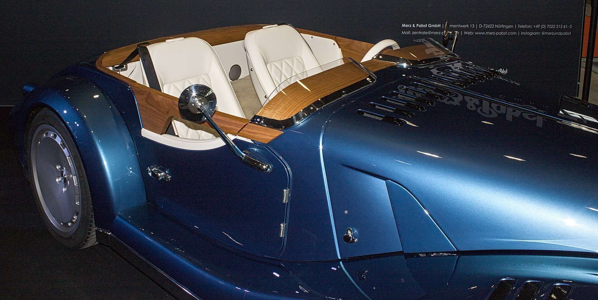 Blue Morgan Midsummer roadster seen from the side showing tan and white interior